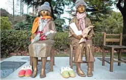  ??  ?? This picture shows two statues symbolizin­g so-called comfort women in a park in Shanghai.