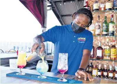  ?? ?? Bartender ‘Swizzle Mixer’ prepares three extra-special cocktails using white rum, peach schnapps, vodka and coconut rum.