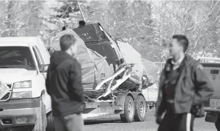  ??  ?? The wreckage of a helicopter crash near Exshaw last year sits on a trailer after being lifted from Loder Mountain. A report by the Transporta­tion Safety Board of Canada says the pilot, Matthew Goodine, was qualified and certified, but had no...