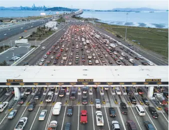  ?? Noah Berger / Special to The Chronicle ?? Traffic streams through the Bay Bridge toll plaza, where an increase could peg the toll at $9.