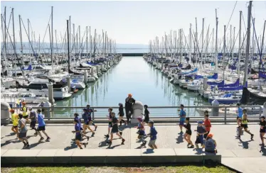  ?? Photos by Michael Short / Special to The Chronicle ?? Participan­ts in the 2017 San Francisco Marathon run along the waterfront at South Beach Harbor.