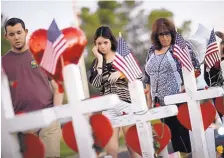  ?? JOHN LOCHER/ASSOCIATED PRESS ?? People visit a makeshift memorial Friday for victims of a mass shooting last Sunday in Las Vegas, Nev.