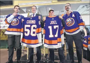  ?? "1 1)050 ?? In this photo provided by the Office of New York Governor Andrew M. Cuomo, Gov. Cuomo, centre left, poses with performer and Long Island native Billy Joel, centre right, at a news conference at Belmont Park in Elmont, N.Y., Wednesday.