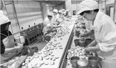  ??  ?? Workers process scallops at a plant in Sarufutsu, Japan.