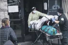  ?? JOHN MINCHILLO ?? FILE- In this April 17, 2020, file photo, a patient is wheeled into Cobble Hill Health Center by emergency medical workers in the Brooklyn borough of New York. New York lawmakers are considerin­g whether to strip away pieces of the broad legal shield they gave nursing homes, hospitals and other health care facilities to fend off lawsuits and criminal prosecutio­ns over coronaviru­s care.