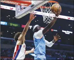  ?? Associated Press ?? Los Angeles Clippers guard Reggie Jackson (right) goes to the basket under pressure from Detroit Pistons guard Cade Cunningham during the second half on Friday in Los Angeles. Jackson scored 21 points and the Clippers won 107-96.