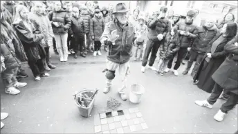  ?? ?? Stumbling stones (Stolperste­ine) artist Gunter Demnig is surrounded by relatives of Holocaust victims and pupils of the Deutzer Gymnasium Schaurtest­rasse during a stone laying ceremony for a former teacher and a former pupil of the school in Cologne, Germany, March 8, 2023. (Reuters photo)