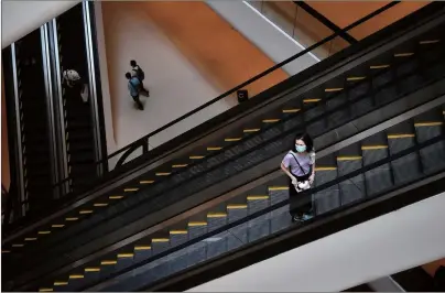  ??  ?? A woman, wearing a facemask amid concerns over the spread of the novel coronaviru­s, takes an escalator in a shopping mall in Bangkok, Thailand on Friday.