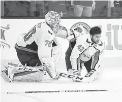  ?? ETHAN MILLER/GETTY IMAGES ?? Capitals goalie Braden Holtby checks on teammate Tom Wilson after Wilson was hurt in a collision with Vegas’ Ryan Reaves on Wednesday.