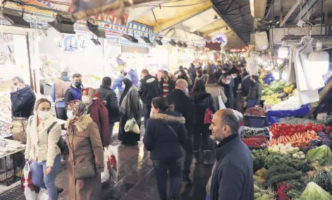  ??  ?? People wearing protective masks shop at a local market, amid the coronaviru­s outbreak, in the capital Ankara, Turkey, Feb. 24, 2021.