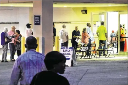  ?? LANNIS WATERS / THE PALM BEACH POST ?? Voters stream into the Supervisor of Elections office Monday just after 7 a.m. for the start of early voting. At Delray Beach’s Hagen Ranch Road Library, 500 residents had voted by mid-morning. Polls will be open 7 a.m. to 7 p.m. daily through Nov. 6.