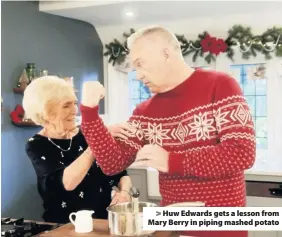  ??  ?? > Huw Edwards gets a lesson from Mary Berry in piping mashed potato