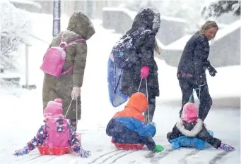  ?? ?? Slip-sliding away: Sledging children are towed at Buxton, Derbyshire, yesterday