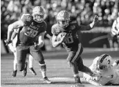  ?? PAUL W. GILLESPIE / TNS ?? Navy quarterbac­k Malcolm Perry, center, returns to help anchor the Midshipmen's run-heavy offense.