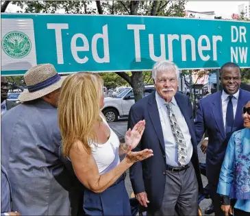  ?? BOB ANDRES / BANDRES@AJC.COM 2015 ?? Ted Turner (center) was on hand in July 2015 for the unveiling of Ted Turner Drive. The media mogul and founder of CNN was recently honored with a state historical marker at the CNN Center.