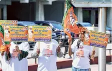  ?? PTI ?? Eager crowd: BJP supporters hold placards ahead of the Lok Sabha election in New Delhi.