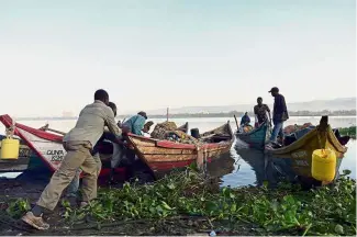  ??  ?? On the job: Fishermen pushing out a boat for a fishing expedition on Lake Victoria. — AFP