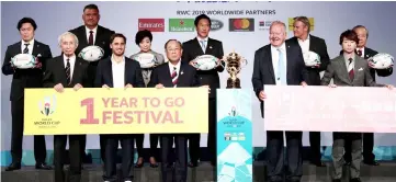  ??  ?? President of the Japan Rugby Football Union Tadashi Okamura (second left), Japan’s national team head coach Jamie Joseph (third left), Tokyo Governor Yuriko Koike (fifth left), Chairman of the Rugby World Cup 2019 Organising Committee Fijio Mitarai (centre), Bill Beaumont (fourth right), Rugby World Cup 2019 Organising Committee CEO Akira Shimazu (right) and other officials pose for a photo next to the Webb Ellis Cup during a kick-off event to mark one year to go to the 2019 Japan Rugby World Cup in Tokyo. — AFP photo