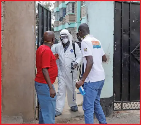  ??  ?? Kenyan health workers dressed in protective suits walk after disinfecti­ng the residence where Kenya's first confirmed coronaviru­s patient was staying, in the town of Rongai