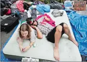  ?? MARK LENNIHAN/AP PHOTO ?? In this Sept. 26, 2011, file photo, Amber Oestreich, left, and Robert Grodt, who are part of the protest movement Occupy Wall Street, rest on a mattress in New York’s Zuccotti Park. People’s Protection Units, also known by their Kurdish initials as the...