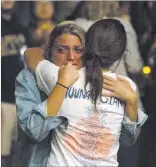  ?? Benjamin Hager ?? LAS VEGAS Review-journal Cttendees of a vigil for victims of Sunday’s mass shooting on the Strip share a hug Monday outside UNLV’S Student Union.