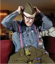  ?? STAFF PHOTO BY TIM BARBER ?? Robert Shriver, 93, puts on the hat he wore during his service in the Burma Campaign.