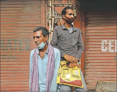  ?? (AP/Manish Swarup) ?? Migrant laborers Nirbhay Yadav (left), 50, and his son Lovelesh Yadav wait to get employed for the day in New Delhi.