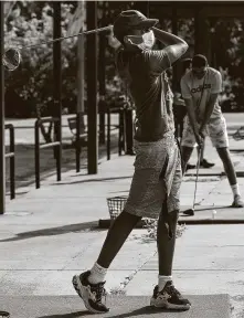  ??  ?? Andrew Starks, 16, tees off at the Hermann Park driving range, where golfers were kept 10 feet apart from each other.