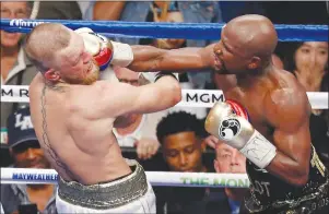  ?? AP PHOTO ?? In this Aug. 26, 2017, file photo, Floyd Mayweather Jr. hits Conor McGregor in a super welterweig­ht boxing match in Las Vegas.