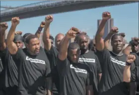  ?? MARY ALTAFFER — THE ASSOCIATED PRESS ?? Members of law enforcemen­t raise their fists during a rally to show support for Colin Kaepernick, Saturday in New York. Kaepernick, the former quarterbac­k for the San Francisco 49ers, became a controvers­ial figure last year after he refused to stand...