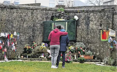  ?? PHOTO: CHARLES MCQUILLAN/ GETTY ?? Legacy:
A mother and child leave flowers at the mass burial site which was formerly part of the Mother and Baby home in Tuam, Co Galway.