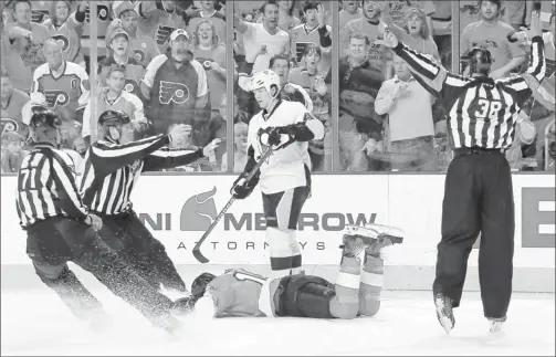  ??  ?? By Len Redkoles, NHLI, via Getty Images
Too far: The Penguins’ Arron Asham, center, is given a 10-minute match penalty Sunday after a hit to the head of the Flyers’ Brayden Schenn. Asham also was suspended.