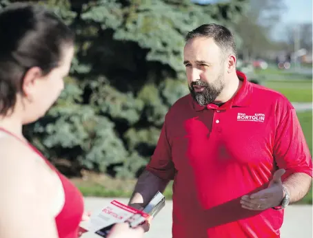  ?? DAX MELMER ?? Rino Bortolin, who is running for the Liberals in Windsor West in the upcoming provincial election, speaks to Aimee Poirer while campaignin­g along Dominion Boulevard. The popular politician is fighting an uphill battle in the district in the face of...