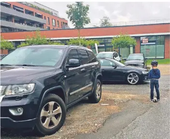  ?? RP-FOTO-JULIA BRABECK ?? An der Straße Zur alten Kaserne parken die Fahrzeuge noch ungeordnet. Luk (6) muss deshalb auf die Fahrbahn treten, um sehen zu können, ob ein Auto kommt.