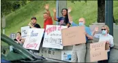  ?? Jeremy Stewart ?? A group of people gather at the entrance to South Rome at the foot of Myrtle Hill to hold signs and wave to passing vehicles.