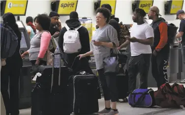  ?? Joe Raedle / Getty Images ?? People wait to check in at the airport in Fort Lauderdale, Fla., where Spirit Airlines canceled flights.