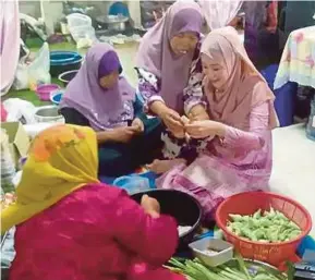  ??  ?? You Narae mencuba membuat sarung ketupat ketika mengunjung­i rumah kenalan di Kampung Petani Sering, baru-baru ini.