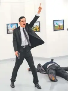  ??  ?? Mevlut Mert Altintas, a 22-year-old member of Ankara’s riot police, gestures after shooting Andrei Karlov, the Russian ambassador to Turkey, on Monday at an art gallery in Ankara, Turkey. Three other people were wounded in the attack. Altintas was...