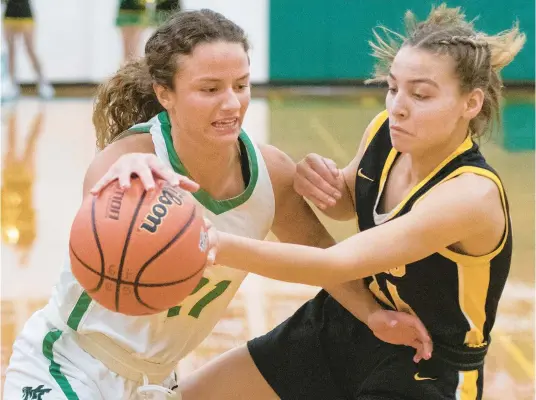  ?? MICHAEL GARD/POST-TRIBUNE ?? Morgan Township’s Madi Lemmons, left, drives against Kouts’ Bella Birky during Saturday’s Class 1A Morgan Township Sectional championsh­ip game in Valparaiso.