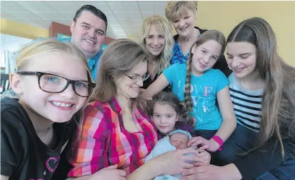  ?? DAVE SIDAWAY ?? Newborn Caitlyn Stewart is surrounded by dad Dale, mom Ann, holding baby, grandma Judith Giles, midwife Marie Brunet, centre back, and sisters, from left, Jessica, Vanessa, Kiera and Aimée.