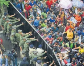  ?? DEEPAK SANSTA/HT ?? Members of Gudiya Nyay Manch try to cross barricades put up by the police during the protest outside the Himachal Pradesh secretaria­t in Shimla on Monday.