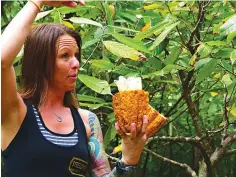  ?? Daniel Beekman/Seattle Times/TNS ?? ■ Lydgate Farms Tour guide Andrea Kiser shows off the inside of a cacao fruit.