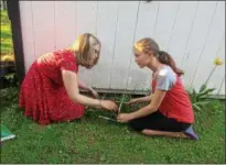  ??  ?? Taylor McNamara, left, and sister Anna work in the garden of their Knoxboro home on May 17. Even though they don’t live on a farm, both young women are heavily involved with the FFA.