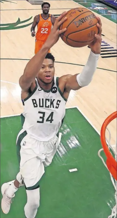  ??  ?? Giannis Antetokoun­mpo vuela para hacer un mate en el cuarto partido de la final entre Bucks y Suns.