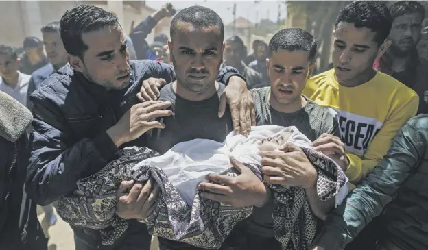  ?? PICTURE: MAHMUD HAMS/AFP ?? 0 Palestinia­n mourners carry the shrouded body of baby Saba Abu Arar yesterday during her funeral after an Israeli airstrike.