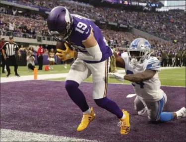  ?? BRUCE KLUCKHOHN ?? Vikings wide receiver Adam Thielen catches a 2-yard touchdown pass behind Lions cornerback Nevin Lawson, right, during first half of game in Minneapoli­s. Thielen became the first player to have eight 100-yard receiving games to start a season, tying Calvin Johnson for the longest streak of such games.