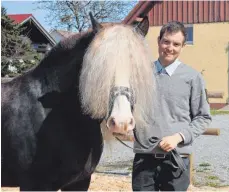  ?? FOTO: PHILIPP RICHTER ?? Clemens Roos vom Haupt- und Landgestüt Marbach arbeitet auf der Servicesta­tion in Zogenweile­r. Der Pferdewirt ist für das Decken der Stuten zuständig. Mit im Bild ist der Schwarzwäl­der Victor.