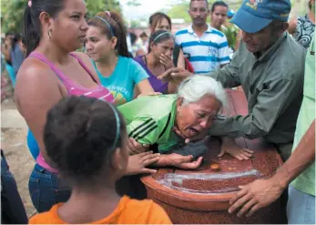  ?? AP PHOTO ?? A woman grieves over the coffin containing the remains of Jose Manuel Perez, 28, at the Municipal Cemetery of Valencia, Venezuela, on Friday.