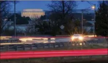  ?? (AP PHOTO/J. DAVID AKE ?? Traffic streaks along U.S. Highway 50 early in the morning, Friday, March 30, 2018 across the Potomac River from Washington in Arlingotn, Va. The Trump administra­tion is expected to announce that it will roll back automobile gas mileage and pollution...