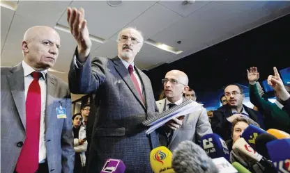  ??  ?? GENEVA: Syrian ambassador to UN and head of the government delegation Bashar Al-Jaafari (center) gestures as he holds a press conference during the Syria peace talks. — AFP